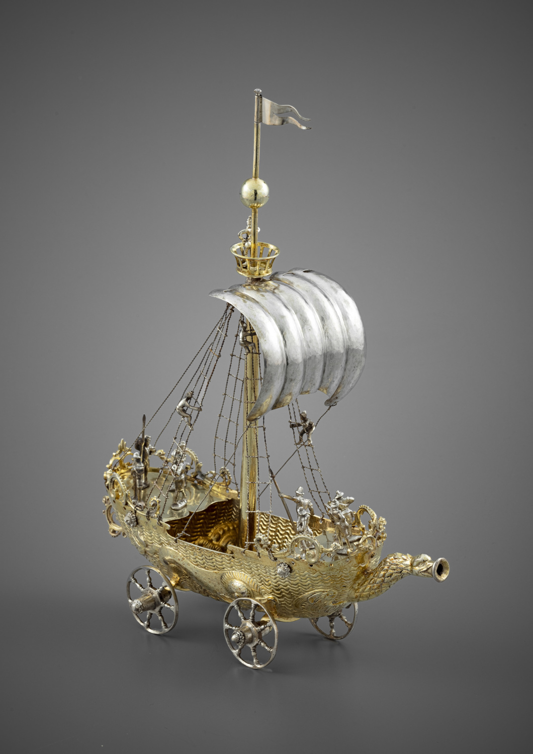 A silver and silver-gilt drinking cup in the shape of a vessel on wheels - Galerie Kugel